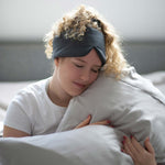 Woman hugging Organic Bamboo Pillowcase and wearing a bamboo sleep mask