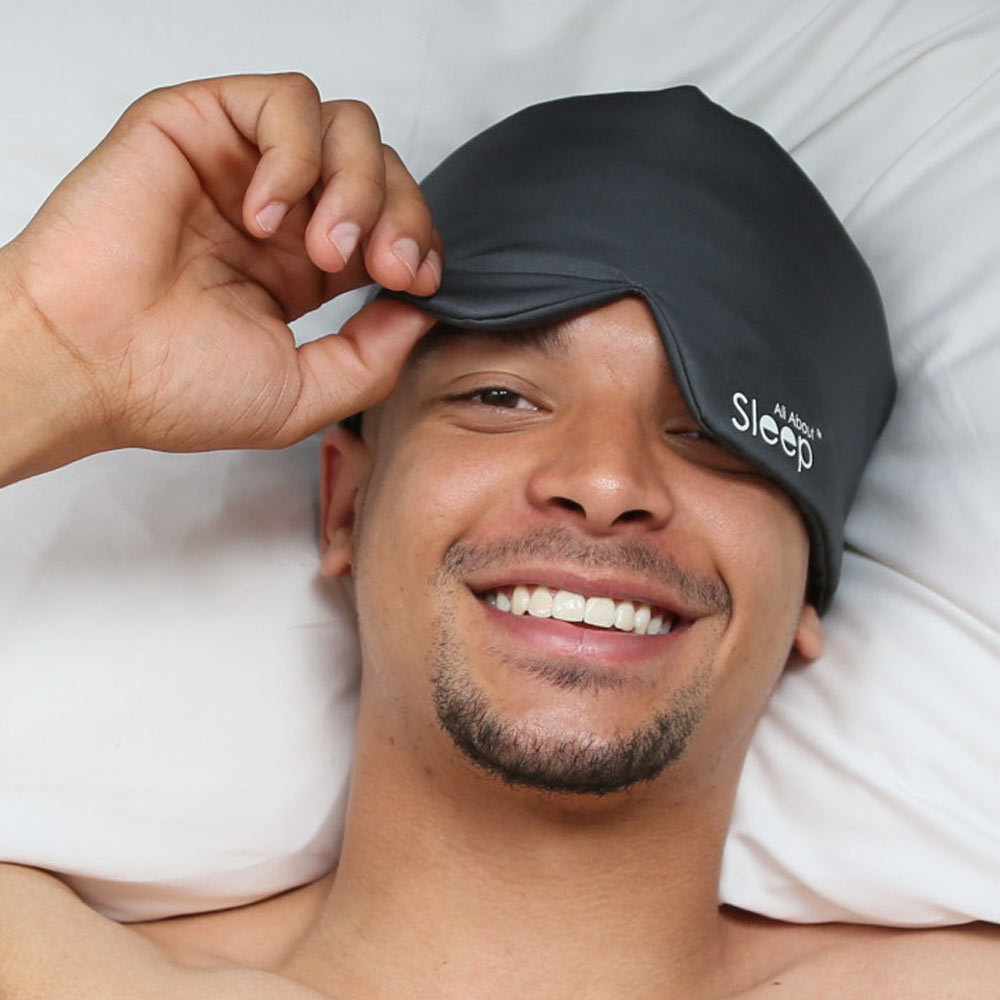 Man wearing organic bamboo sleep mask in bed